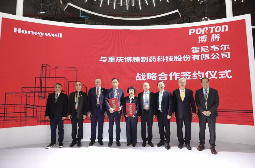 A group of people standing in front of a red banner.