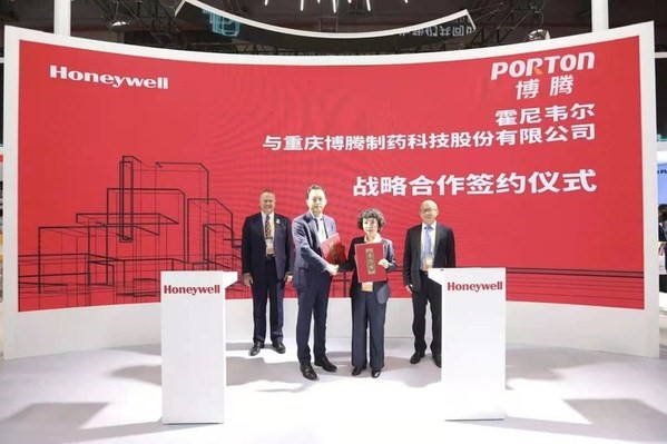 A group of people standing in front of a red banner.